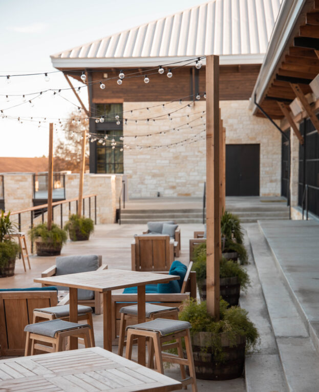 Patio dining area with wooden tables and string lights