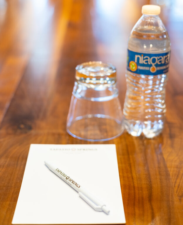 notepad pen glass and water bottle on table