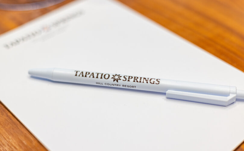 Pen on notepad with tapatio springs logo