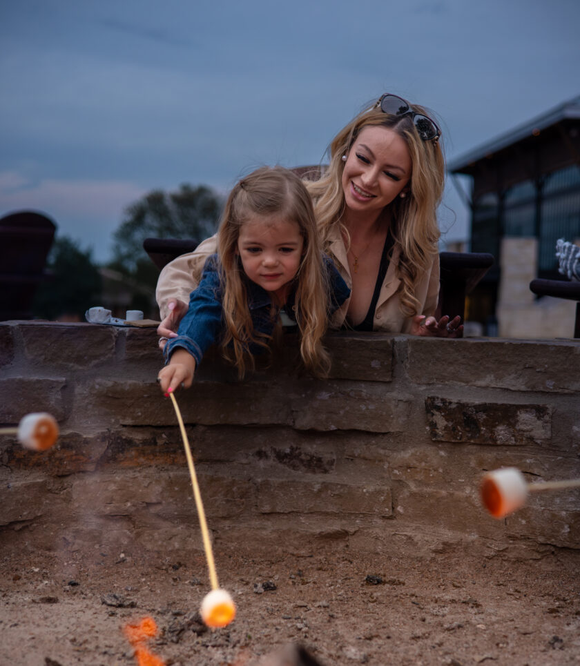 mother and child roasting marshmallows at fire pit