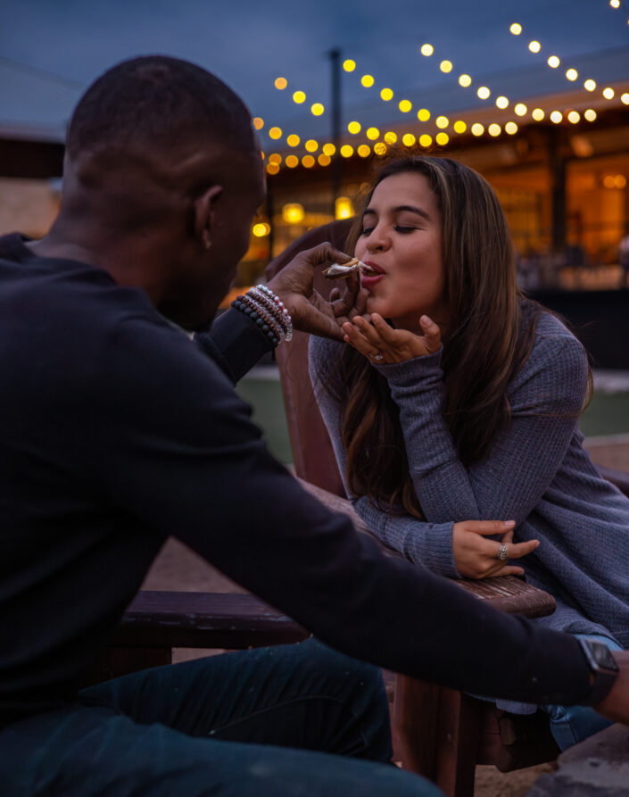 couple roasting marshmallows by fire pit