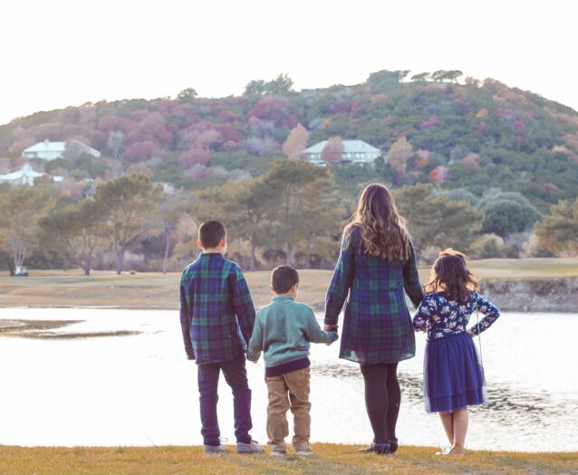 family standing by lake with hills in background