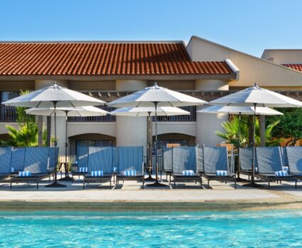 outdoor pool with lounge chairs and umbrellas