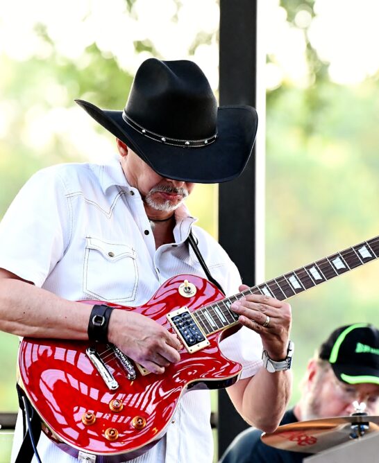man in cowboy hat playing electric guitar