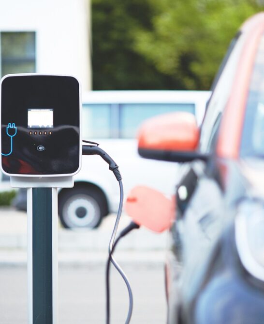 A small car is plugged into an electric vehicle charging station.