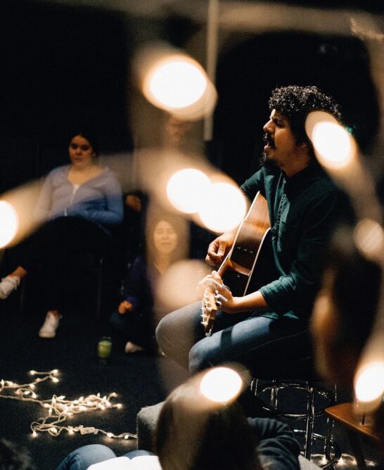 musician playing guitar on stage