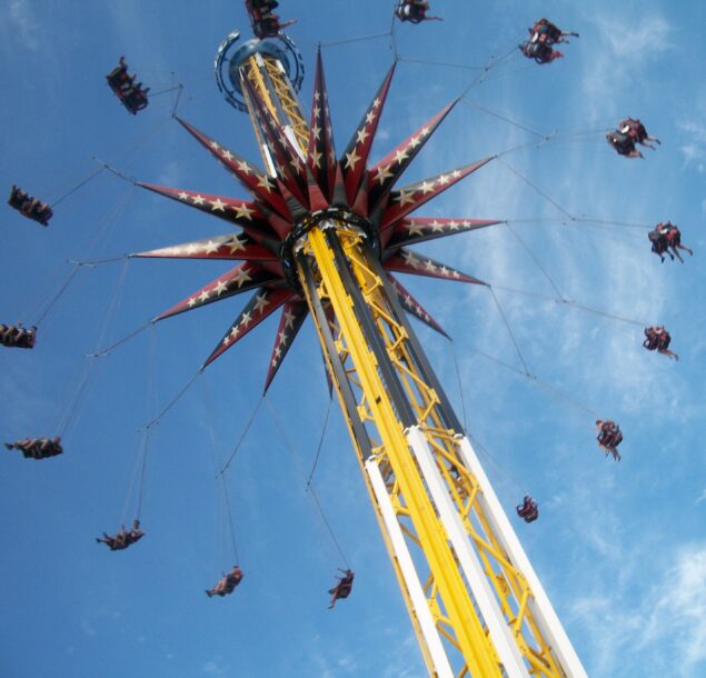 people riding swing ride at amusement park