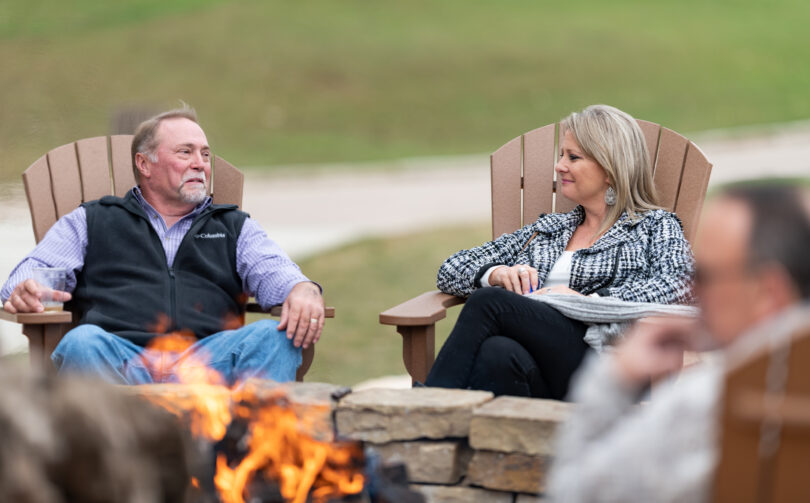 couple sitting by outdoor fire pit
