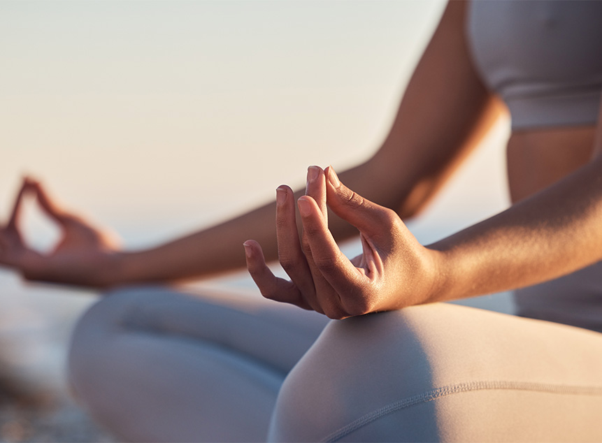 person meditating outdoors with hands in yoga pose