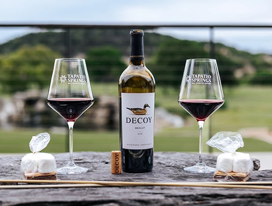 bottle of wine with two glasses on outdoor table