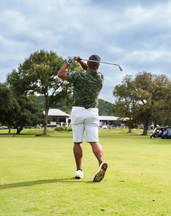 golfer swinging club with crowd watching