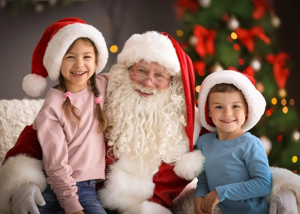 Santa with two children before Christmas tree