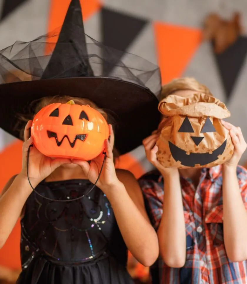 Children holding up jack-o-lanterns