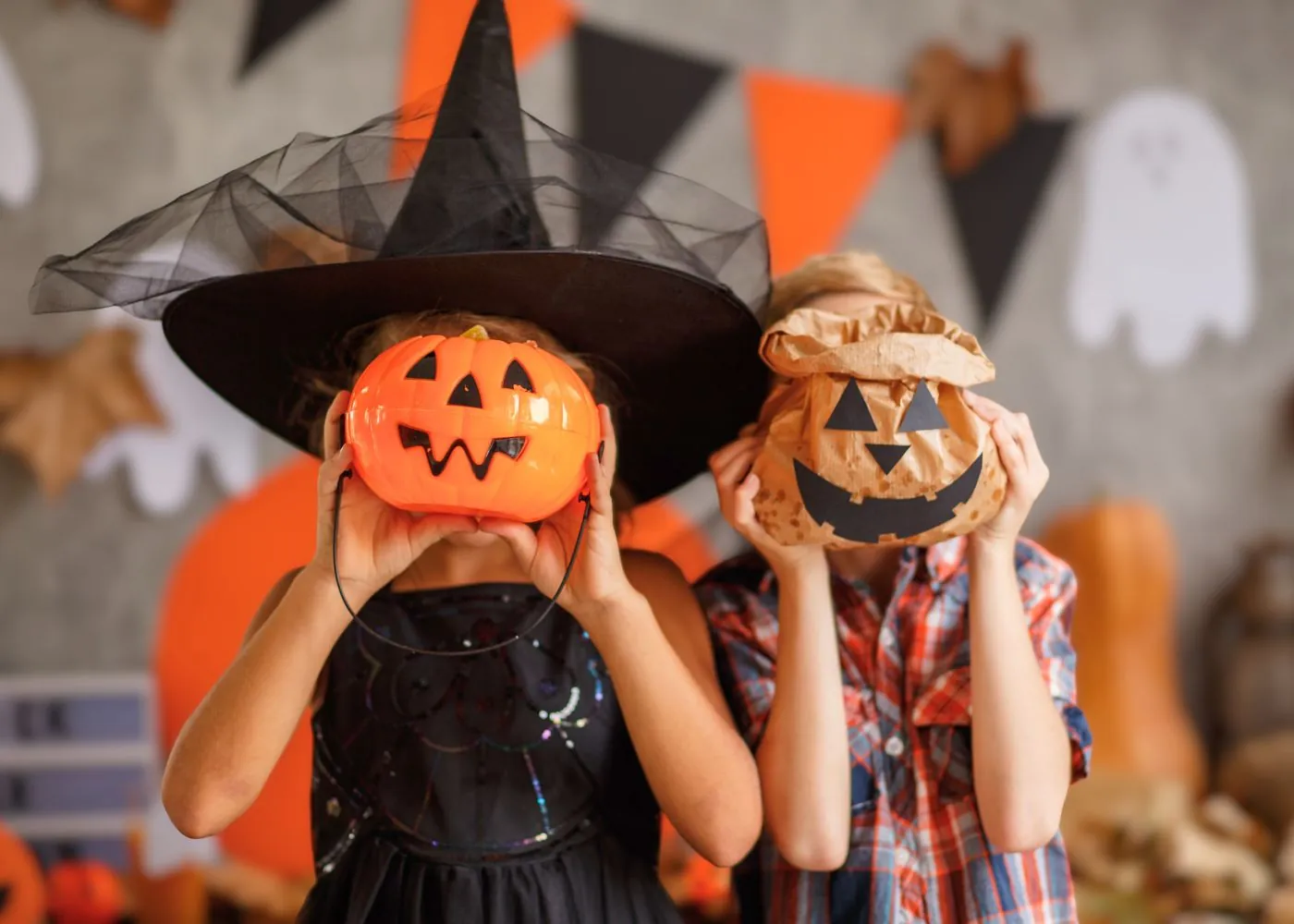 Children holding up jack-o-lanterns